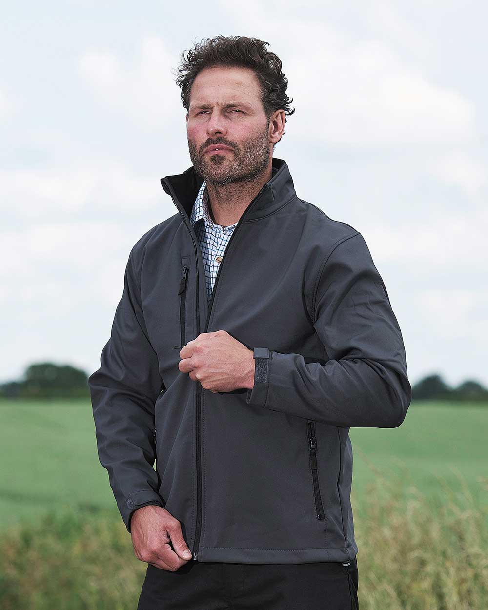 Black coloured Fort Selkirk Softshell Waterproof Jacket on field background 