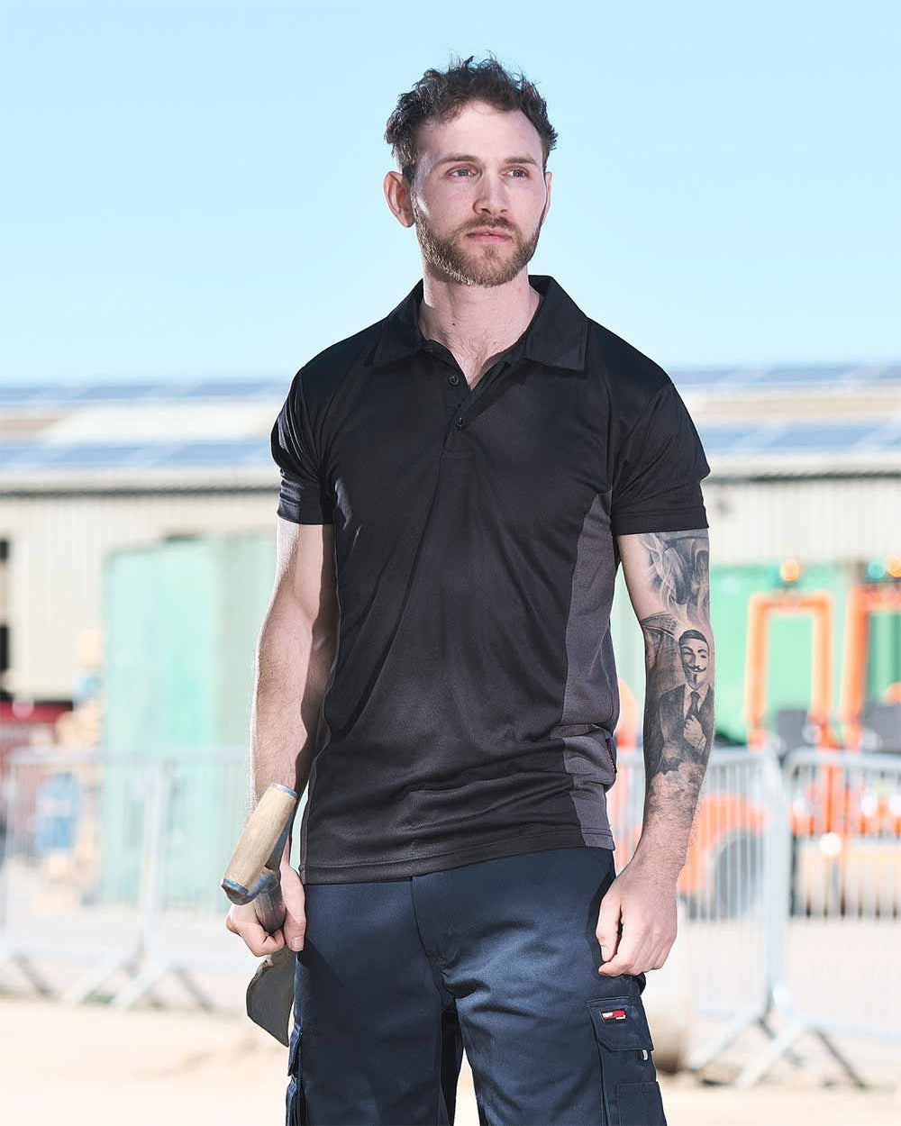 Black Coloured TuffStuff Elite Polo Shirt On A Warehouse Background 