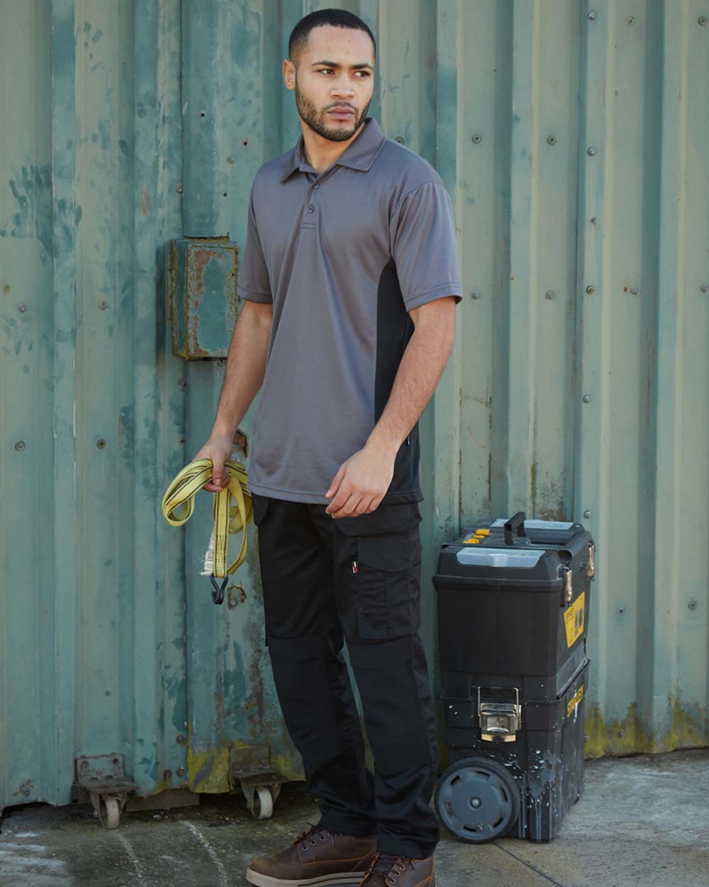 Black coloured TuffStuff ProFlex Work Trousers on Work Site background 